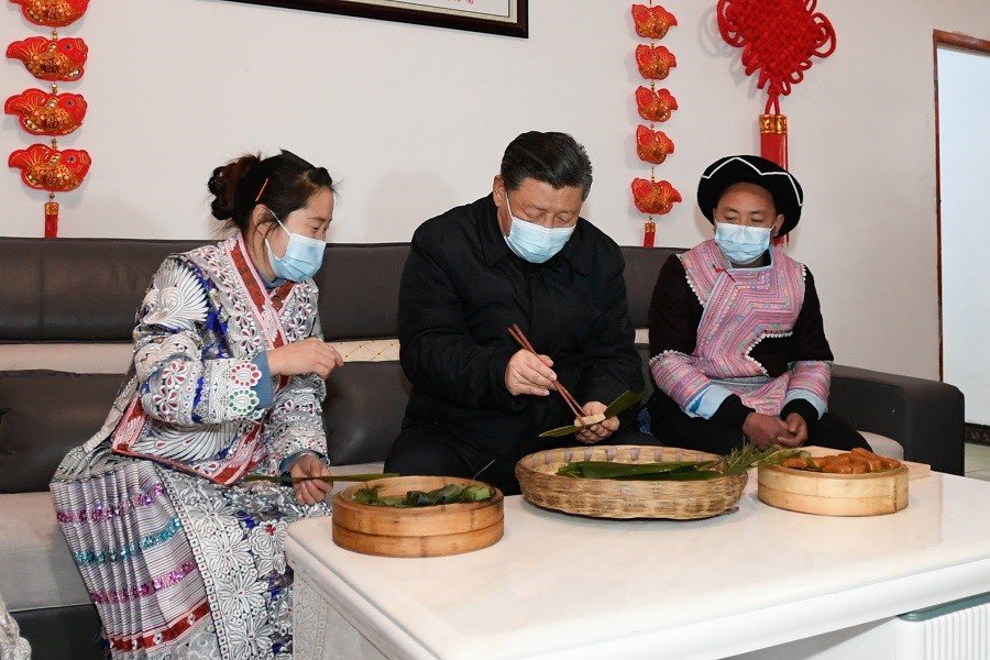 2021年2月3日下午，習(xí)近平在貴州畢節(jié)市黔西縣新仁苗族鄉(xiāng)化屋村苗族村民趙玉學(xué)家，同一家人邊聊家常邊制作當(dāng)?shù)貍鹘y(tǒng)節(jié)日食品黃粑。新華社記者 李學(xué)仁 攝